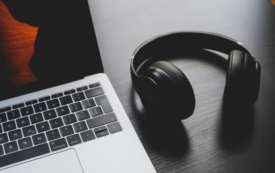 Headphones beside a laptop for transcription work