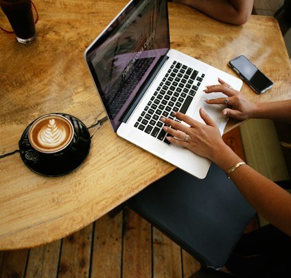Freelance writer typing on a laptop with coffee
